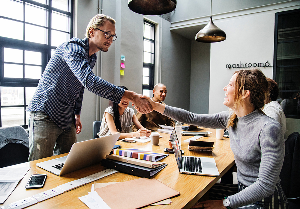 People in a conference room shaking hands